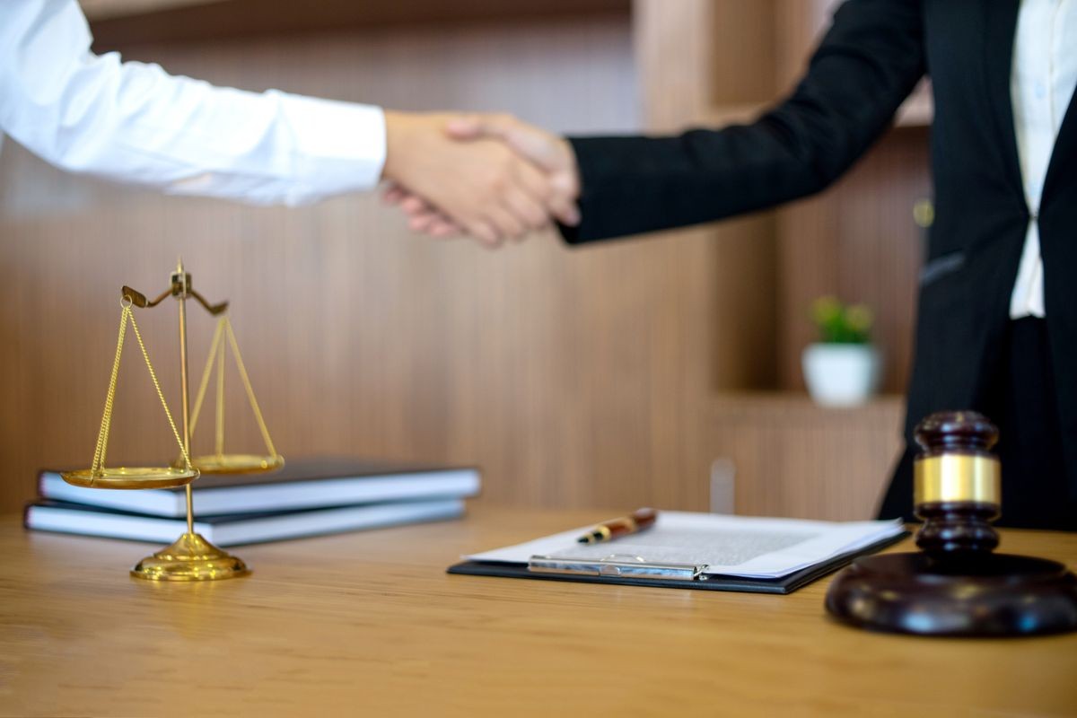 in Law office, Judge woman gavel with Justice lawyers having meeting with team  at law firm in background. Hand shake Concepts of law. 